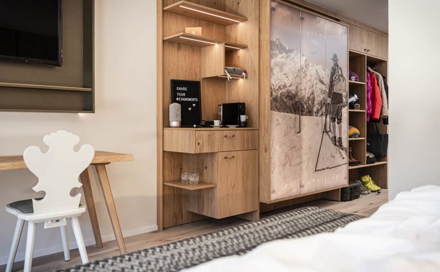 Moderne slaapkamer met houten meubels, tv, bureau en kledingkast