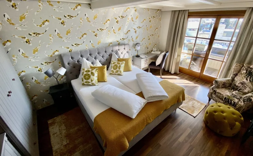 Cozy bedroom with double bed, yellow throw blanket and balcony door