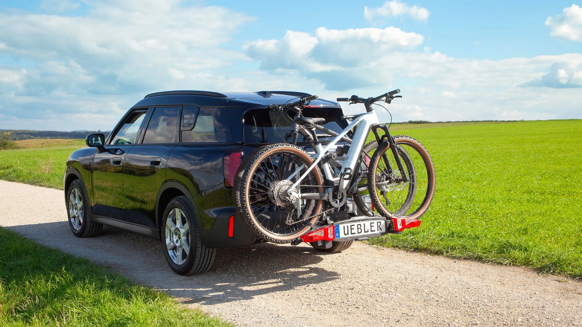 Sicher unterwegs mit dem Testsieger © Karl Pfeifer Schwarzes Auto mit zwei Fahrrädern auf einem Fahrradträger auf einem Feldweg