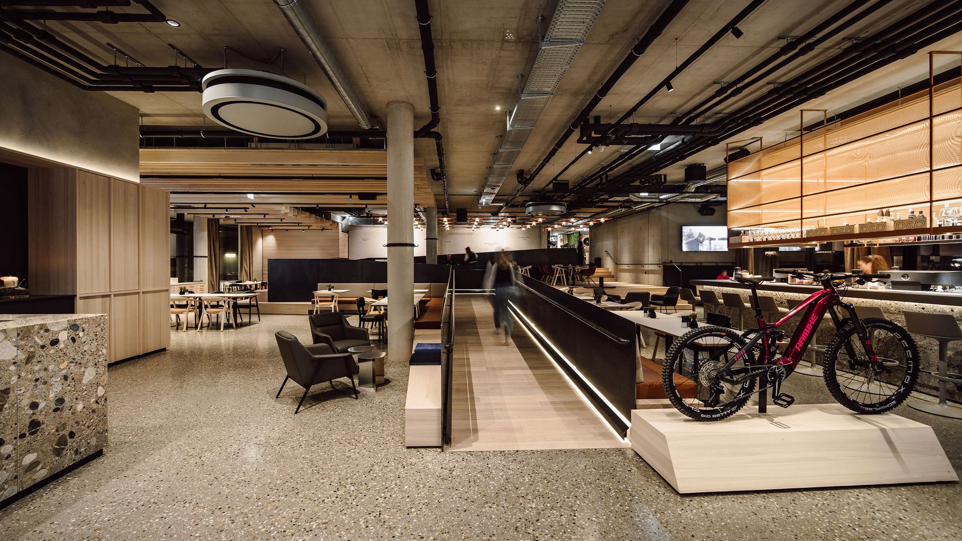 Moderner Innenraum mit Rampen, Sitzbereich und Mountainbike-Ausstellung