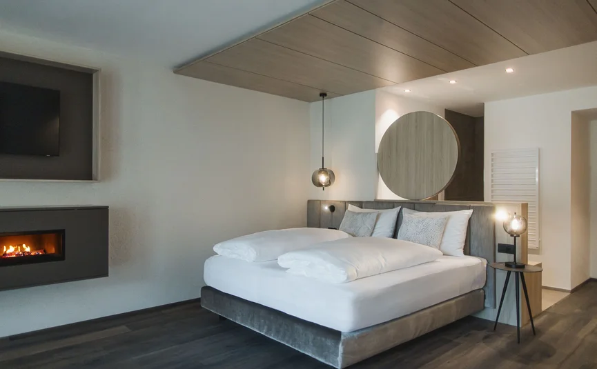 Modern bedroom with double bed and fireplace