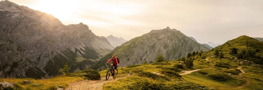 Livigno © Christoph Gramann Fietser op bergpad bij zonsondergang in de Alpen