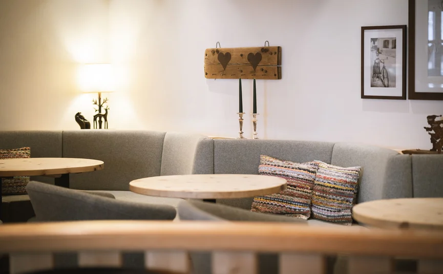 Hotel Innerhofer *** © Lunah Photo & Design Gemütliche Sitzecke mit grauem Sofa, Holztischen und Dekoration an der Wand