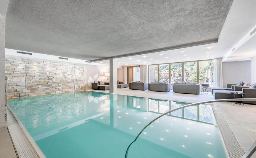 Helles Schwimmbad mit Sitzecke und Bodenscheinwerfern