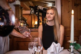 Golf days deluxe / 3 nights Waiter pouring water into a glass for a woman in a cozy restaurant