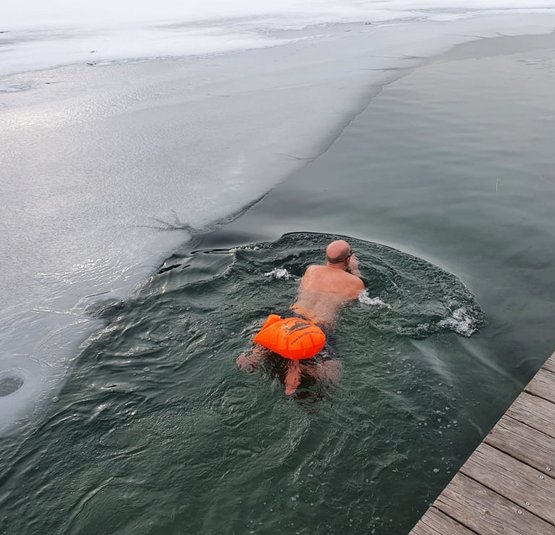 Man zwemt in ijskoud water tussen bevroren meren