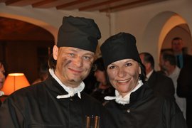 Lächelnde Menschen mit schwarzer Kleidung und Schminke auf dem Gesicht bei Feier