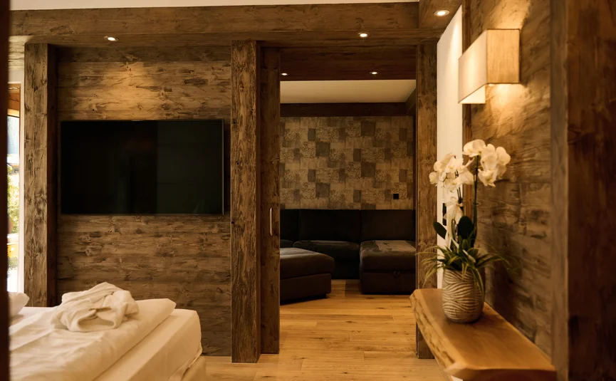 HIRBEN Naturlaub **** © David Rasche Cozy hotel room with wood accents, bed, TV, and orchid plant on shelf