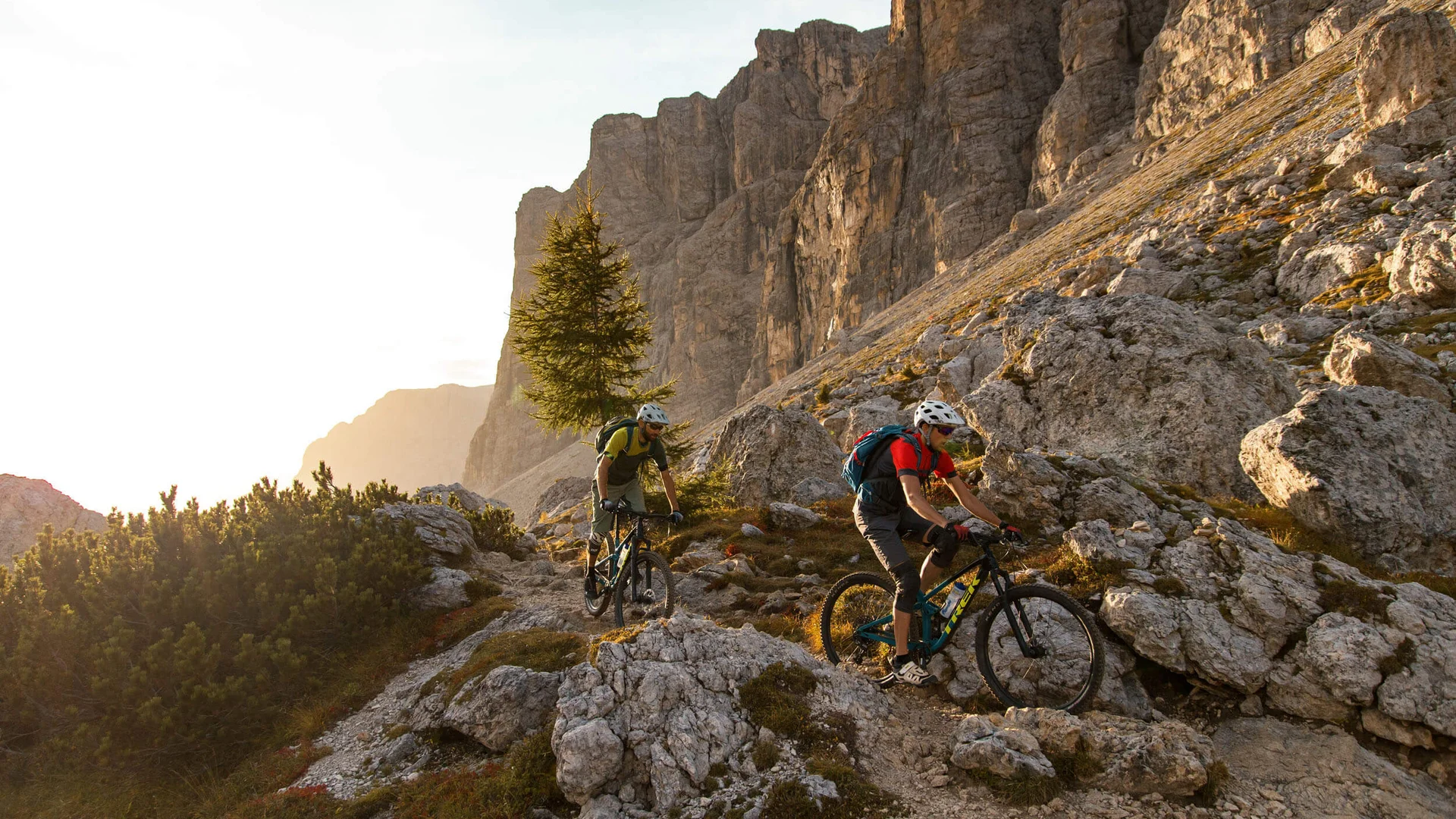 Zwei Mountainbiker fahren auf steinigem Bergpfad in den Alpen