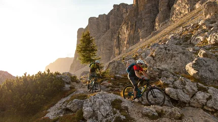 Twee mountainbikers op rotsachtig bergpad in de Alpen