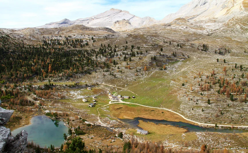 Berglandschaft mit kleinem See, Wegen und vereinzelten Häusern im Tal