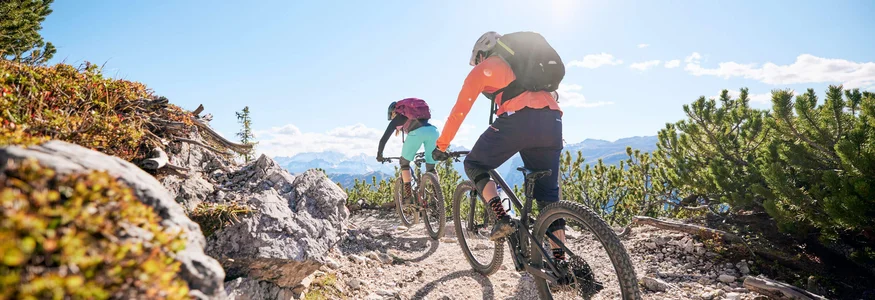 Mountainbike-Urlaub in Alta Badia © Tobias Köhler Zwei Mountainbiker fahren auf felsigem Bergpfad bei sonnigem Wetter
