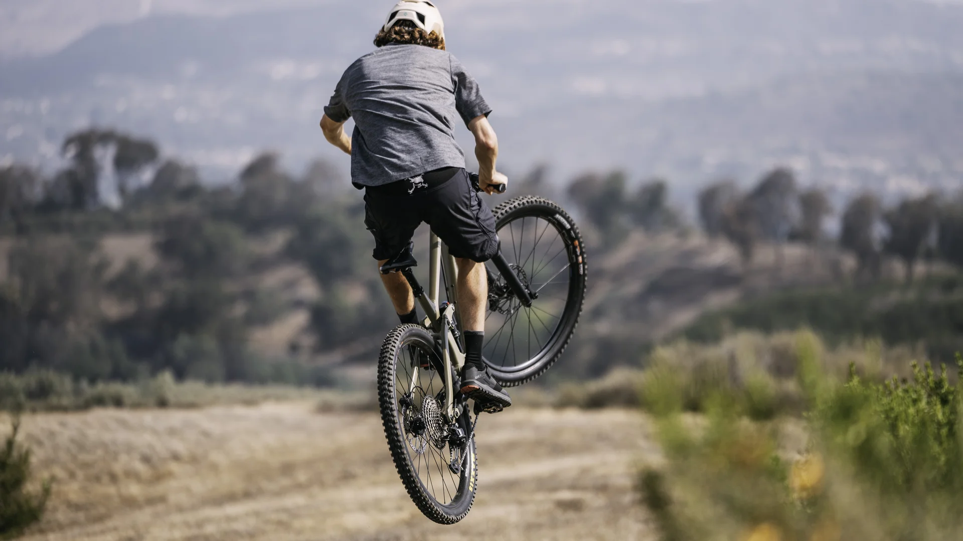 Mountainbiker springt mit dem Fahrrad über einen steinigen Weg