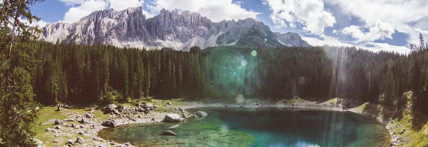Dolomiten - Eggental © WOM Medien - Stefan Schopf Bergsee mit klarem Wasser, umgeben von Wald und Bergen unter blauem Himmel
