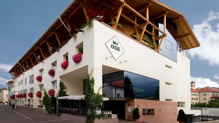 Modernes Hotelgebäude mit Blumen und Holzdach im Dorf