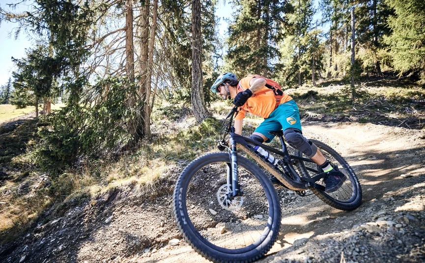 Mountainbiker fährt auf einem bergigen Waldweg