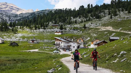 Ein Herbst-Wochenende in San Vigilio © Norman Bielig Zwei Mountainbiker auf Bergweg vor Almhütte und bewaldetem Gebirge