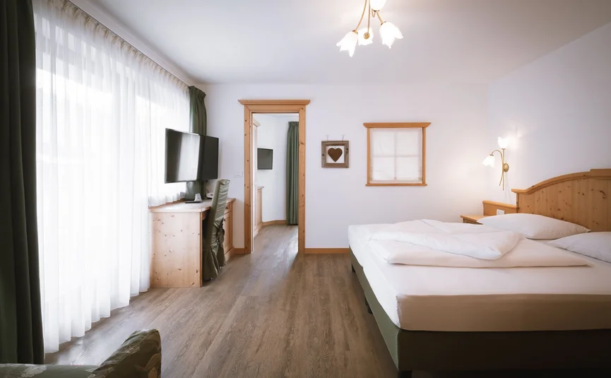 Hotel Innerhofer *** © Lunah Photo & Design Helles Hotelzimmer mit Doppelbett, Fernseher und Holzmöbeln