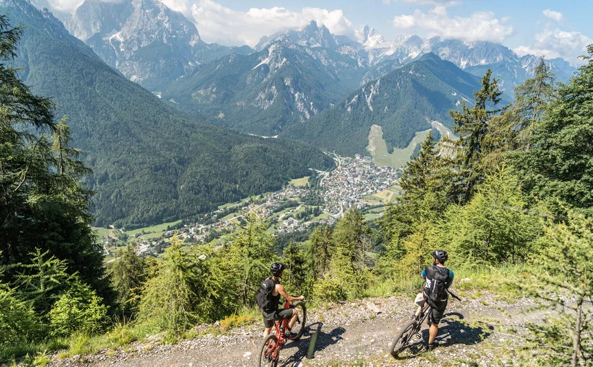 Mountainbike Urlaub in den Julischen Alpen © Kranjska Gora - Grega Teraž Zwei Mountainbiker auf Waldweg mit Blick auf Tal und Berge
