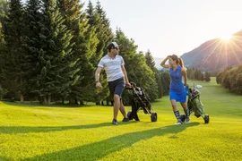 15. Charity Wine & Golf Cup / 4 nights Two golfers walking with golf carts on a sunny golf course