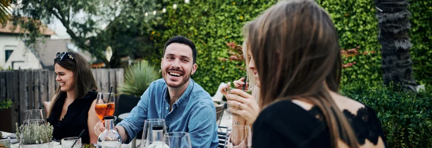 Menschen genießen ein geselliges Getränk an einem geschmückten Gartentisch