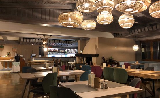 Lifesporthotel Hechenmoos *** © Multivisual Art Gemütliches Restaurant mit hölzernen Tischen, bunten Stühlen und dekorativen Lampen