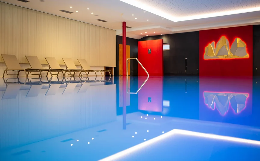 Innenpool mit Liegestühlen und moderner Wanddekoration