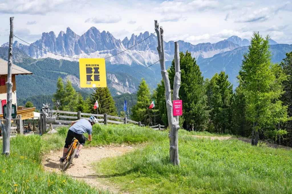 Mountain biker riding a trail with mountain scenery at Brixen
