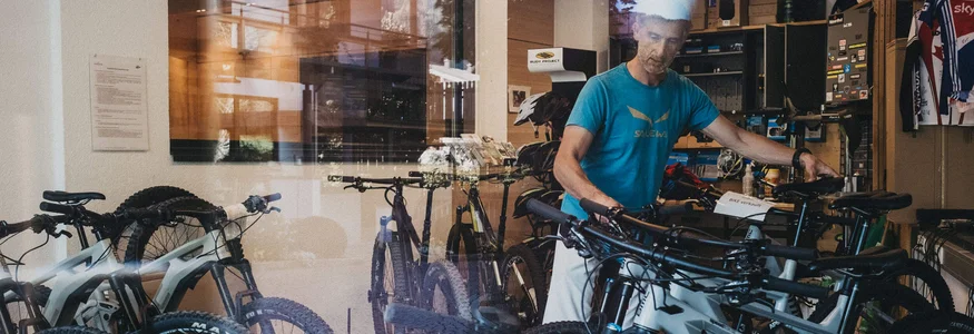Hotel Rupertus: Ein Retreat für Yogis und Biker © Biohotel Rupertus Mann in Fahrradladen mit mehreren Mountainbikes