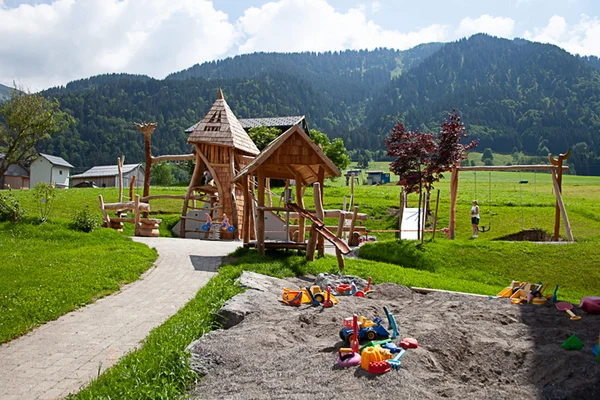 Biking with the family © Alpen Hotel Post Children's playground with wooden structures and sandbox by mountains