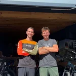 Zwei Männer vor einem Bike-Shop mit Mountainbikes im Hintergrund
