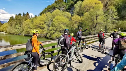 Gruppe von Radfahrern mit Helmen auf einer Brücke in der Natur