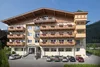 Hotel mit Blumenschmuck an Balkonen und Autos vor dem Eingang