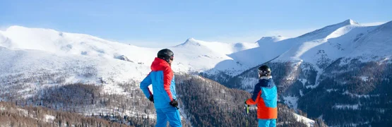 Hotel 3=2 Winter Ski Opening / 3 nights Two skiers standing on snowy slope overlooking snow-covered mountains