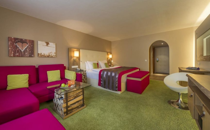 Modern hotelkamer met roze bank en groen tapijt