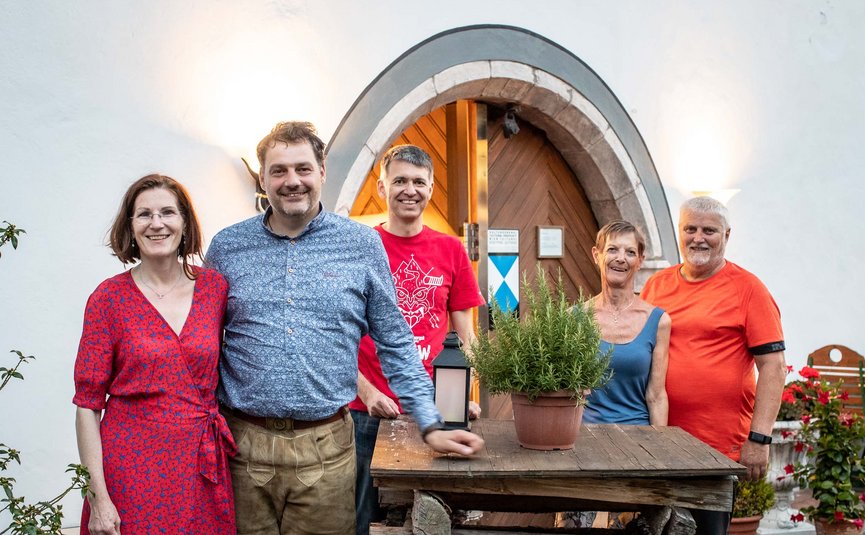 Landhotel Agathawirt *** © Bikeboard.at - Erwin Haiden Five smiling people stand in front of a wooden door with a wooden table and plants