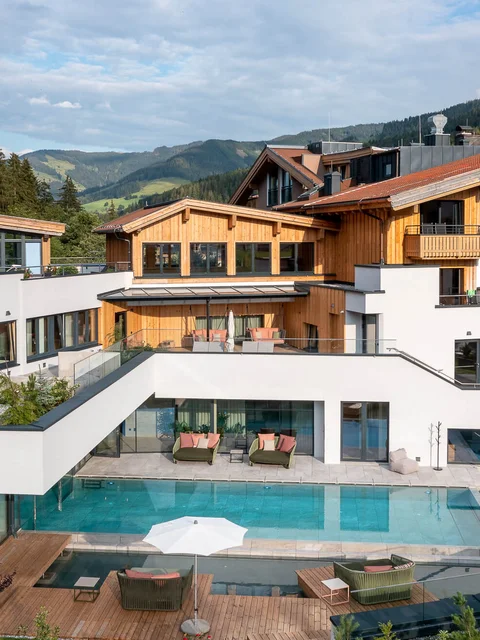 Moderne Ferienanlage mit Pool und Holzarchitektur in den Bergen