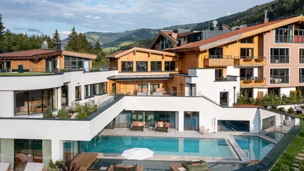 Moderne Ferienanlage mit Pool und Holzarchitektur in den Bergen