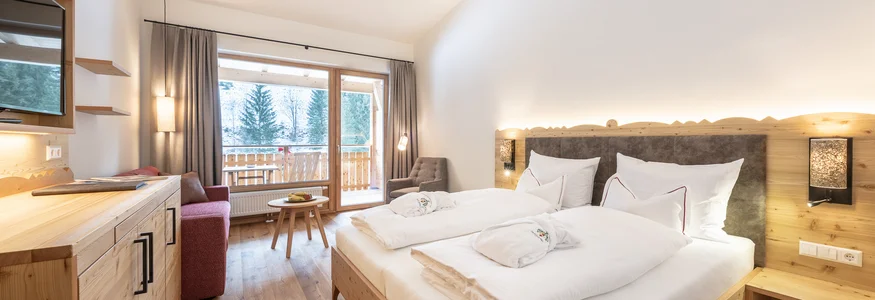 Helles Schlafzimmer mit Doppelbett, Balkon und Holzdekor