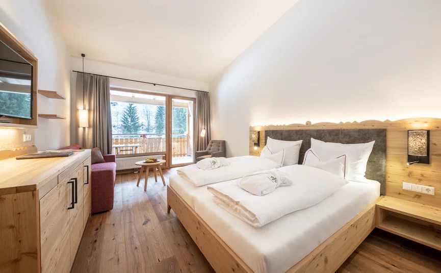 Helles Schlafzimmer mit Doppelbett, Balkon und Holzdekor