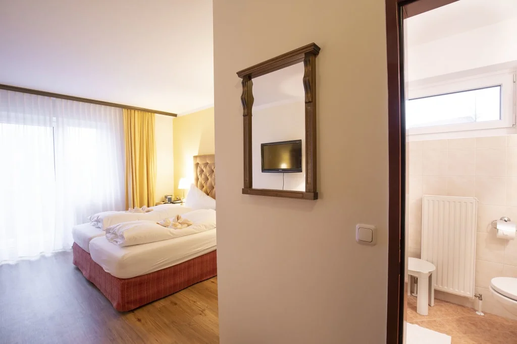 Lichte hotelkamer met twee bedden en aangrenzende badkamer