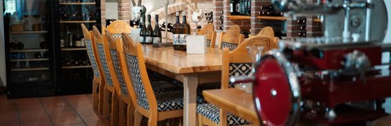 Wijnkelder met houten tafel, stoelen en wijnflessen op stenen planken