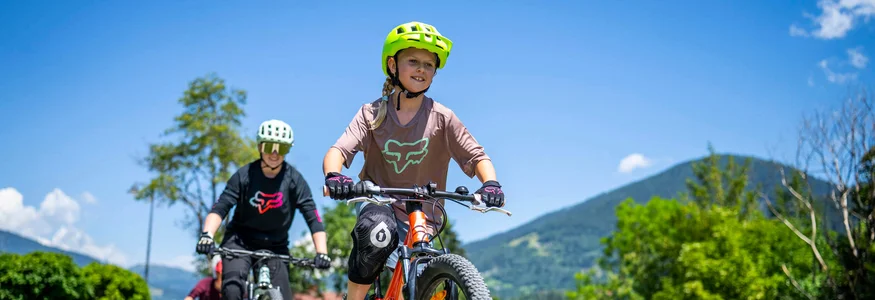 BEST OF Familien-Bikeurlaub © Gert Perauer Kinder fahren Mountainbikes auf einer Brücke im Freien bei sonnigem Wetter