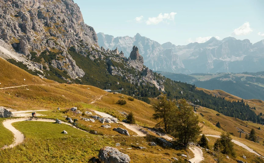 Two mountain bikers on a winding trail in the Dolomite Mountains
