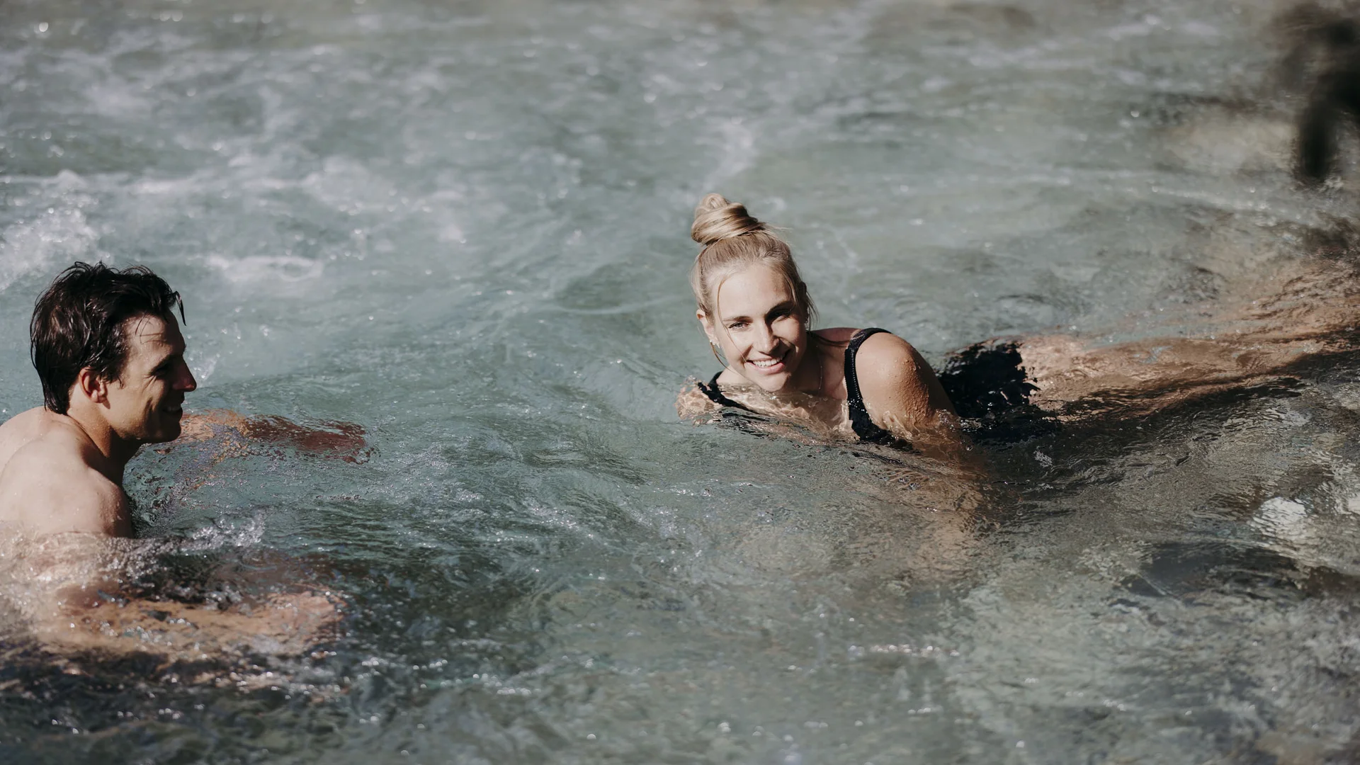 Bikeurlaub per Bahn Mann und Frau entspannen in einem natürlichen Whirlpool mit sprudelndem Wasser
