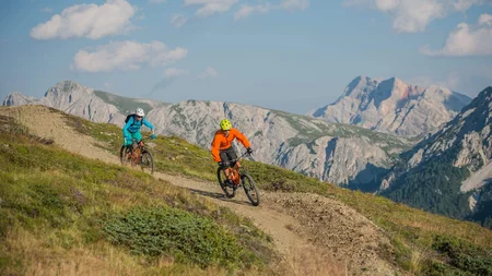 Ein Herbst-Wochenende in San Vigilio © Harald Wisthaler Zwei Mountainbiker fahren auf einem Bergweg mit Bergen im Hintergrund