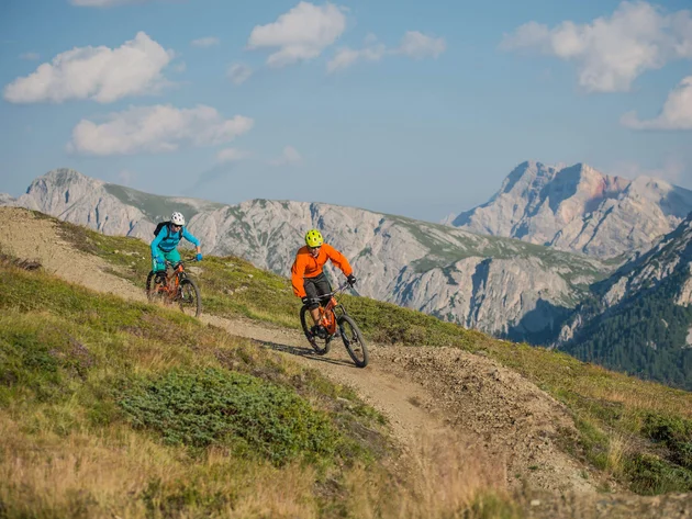 Ein Herbst-Wochenende in San Vigilio © Harald Wisthaler Zwei Mountainbiker fahren auf einem Bergweg mit Bergen im Hintergrund