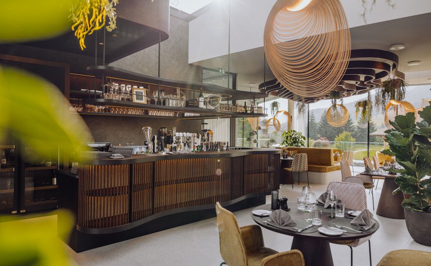 Puradies © creatingclick Modernes Restaurant mit Bar, dekorativen Lampen und Panoramafenstern mit Waldblick