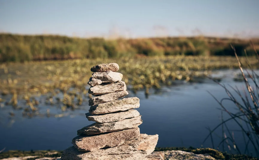 Stacked stones on a lakeshore under clear sky