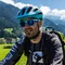 Gruppe von Radfahrern auf einem Landweg in grüner Berglandschaft